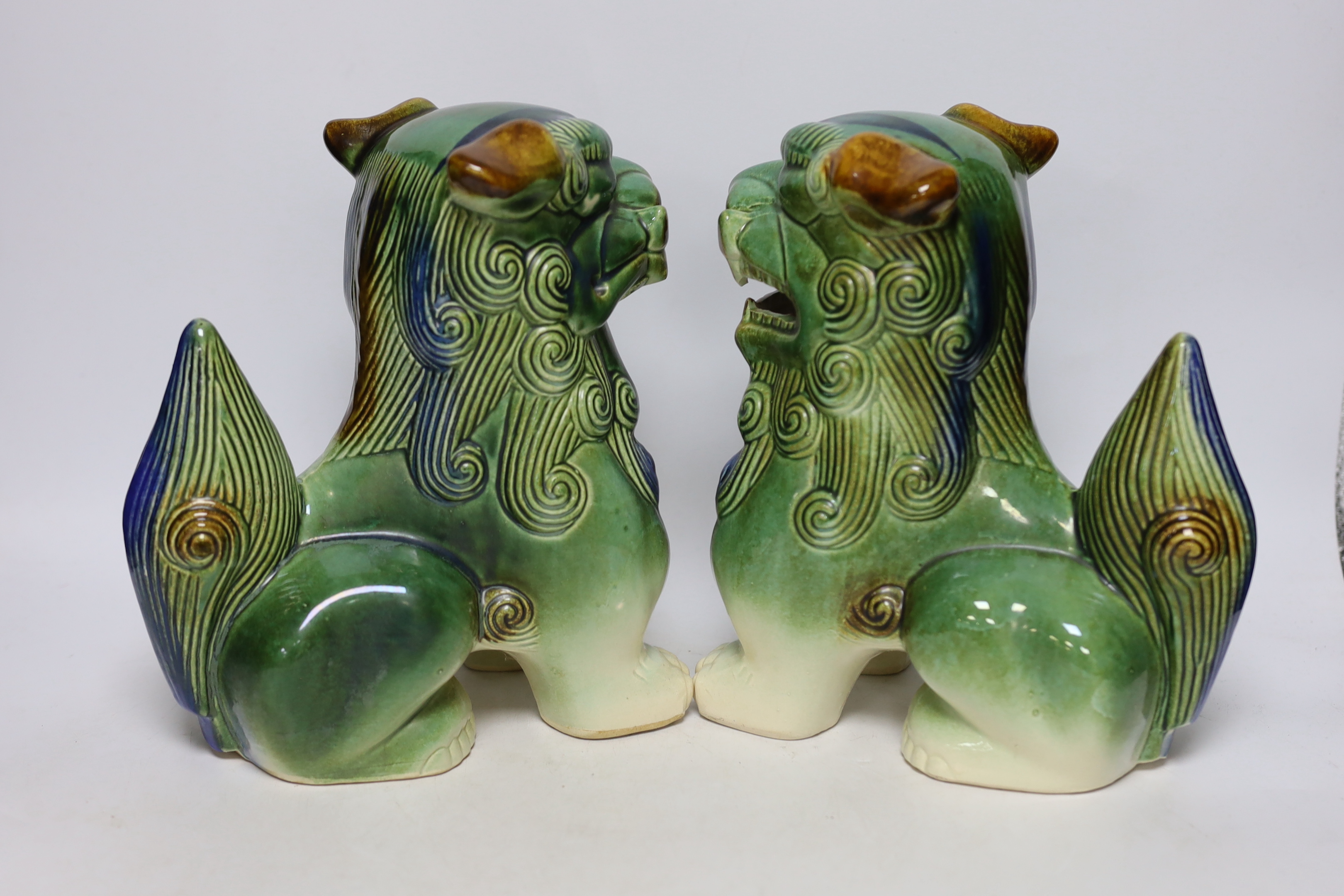 Two Chinese blue and white with iron red ‘dragon’ vases and a near pair of lion dogs, tallest 26cm